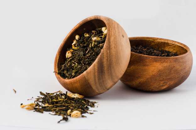 Green tea and black Tea in wooden bowls